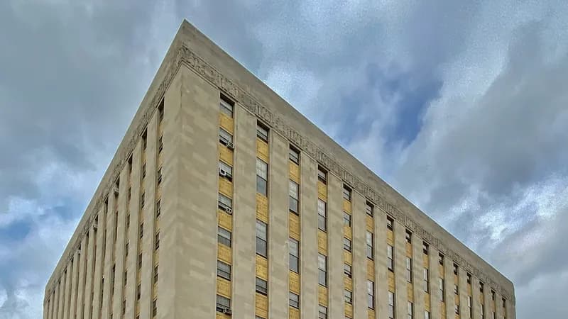 The limestone Bronx County Courthouse on the Grand Concourse under a cloudy sky.