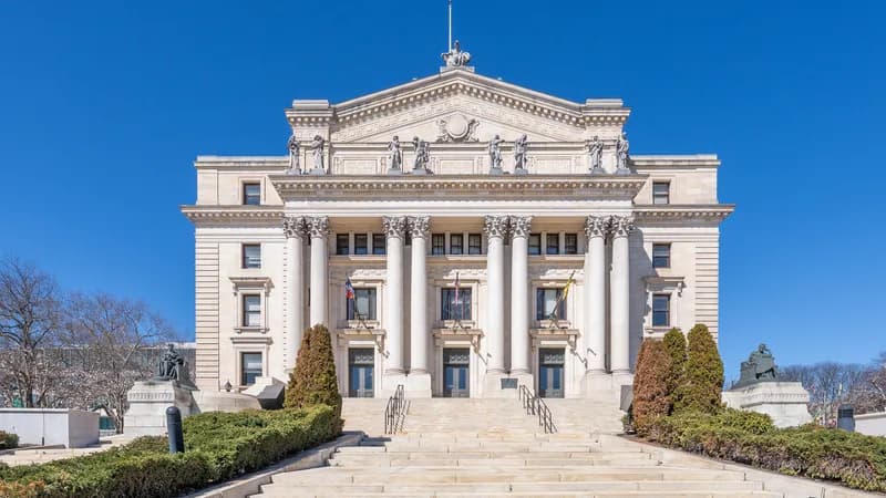 Columned facade, statues and wide entrance stairs of the historic Essex County Courthouse in Newark, New Jersey.