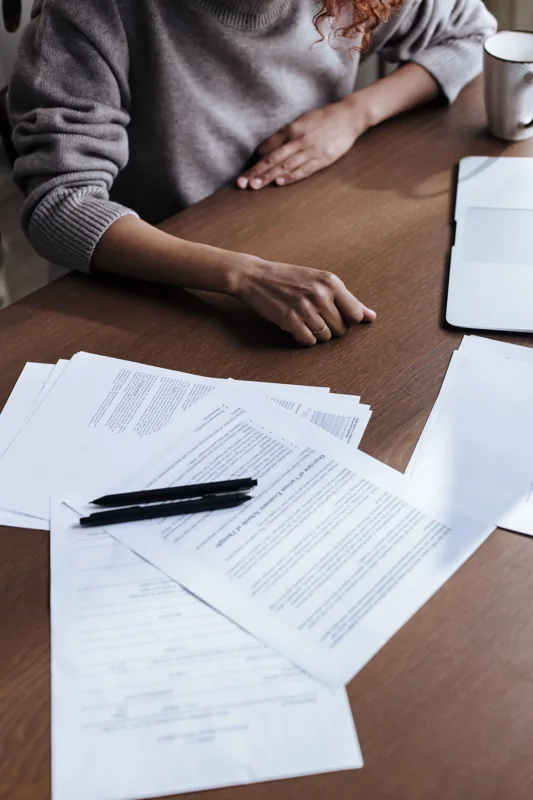 Documents and pens spread across a desk during a review.