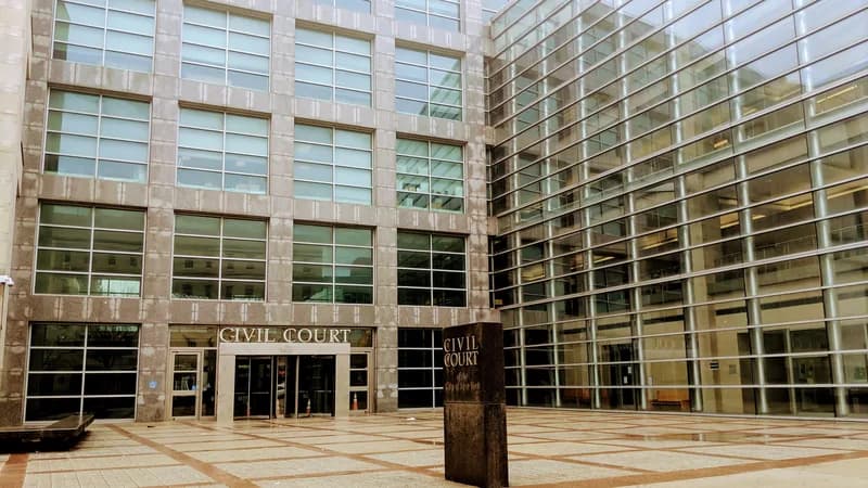 The entrance plaza of the Civil Court building on Sutphin Boulevard in Jamaica, Queens, with “Civil Court” lettering over the doors.