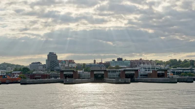 The St. George Ferry Terminal on Staten Island seen from the water under a cloudy sky.