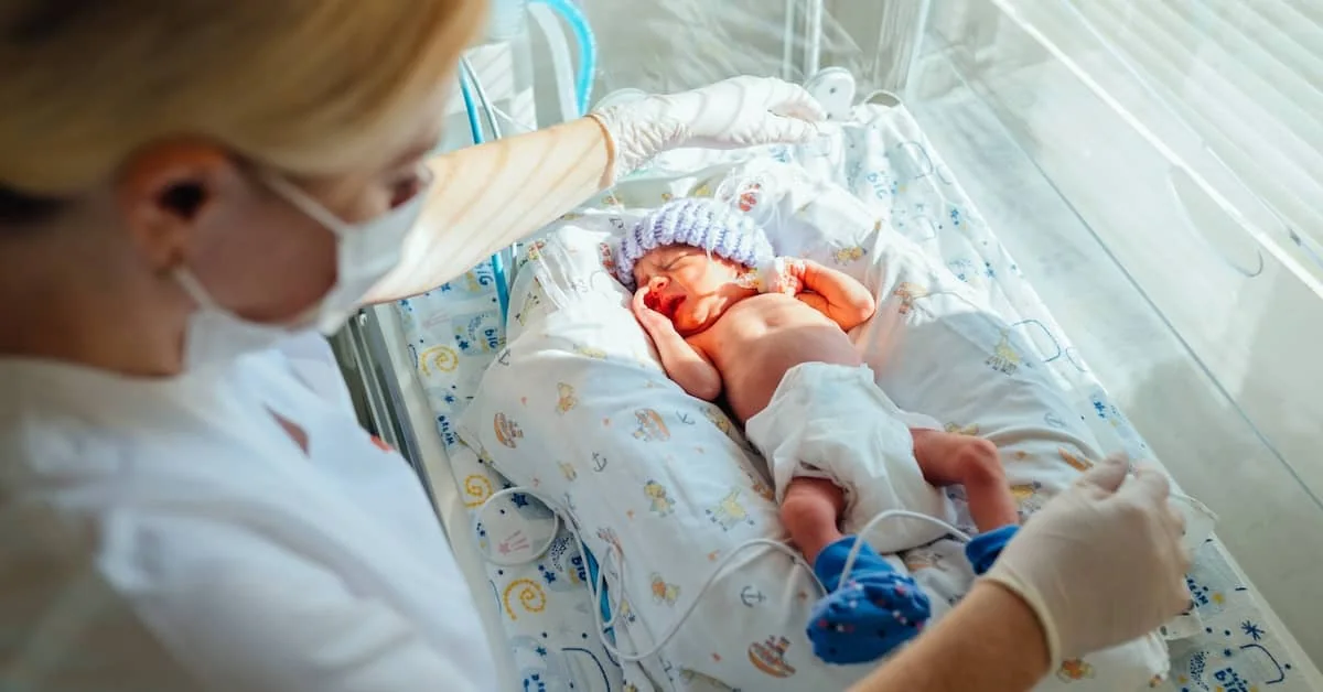 Clinician caring for a newborn in a hospital bassinet