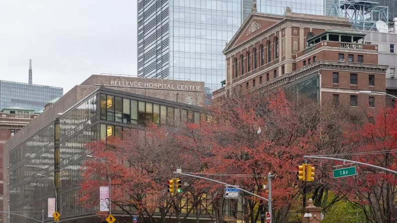 Bellevue Hospital Center on First Avenue in Manhattan, with red autumn trees in front.