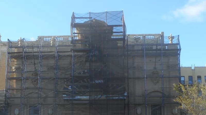 Scaffolding and netting covering the ornate upper facade of the former Paradise Theater on the Grand Concourse in the Bronx.