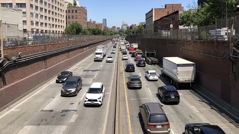 Cars, box trucks and a tractor-trailer on the Brooklyn-Queens Expressway in its brick-walled trench, seen from the Sackett Street overpass.