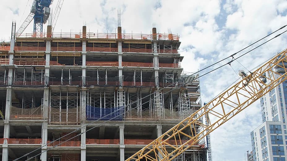 A crawler crane boom angled over a high-rise under construction at Hudson Yards in Manhattan.