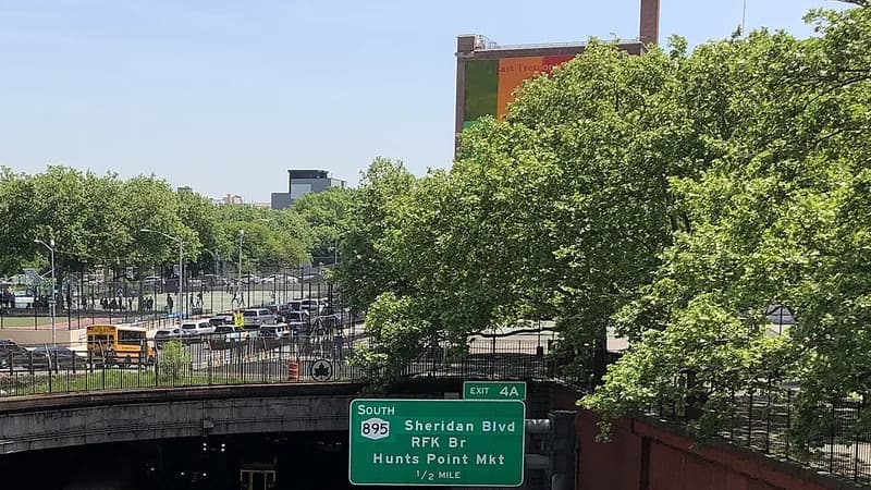 An overhead exit sign on the Cross Bronx Expressway for Sheridan Boulevard, the RFK Bridge and Hunts Point Market, above a tunnel portal.