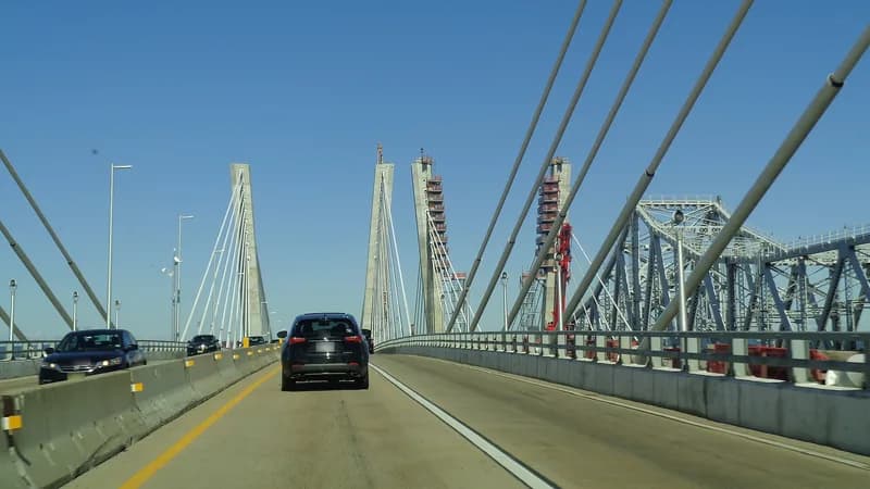 Cars crossing the cable-stayed Goethals Bridge, with the towers ahead and the old steel truss bridge alongside.