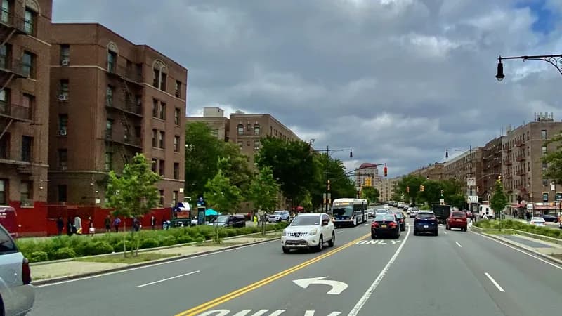 Brick apartment buildings lining the Grand Concourse in the Bronx, looking north between Mount Hope and Tremont.