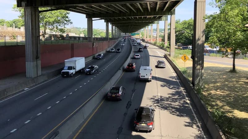 A box truck and cars on the Long Island Expressway beneath an elevated roadway near the 48th Street overpass in Queens.