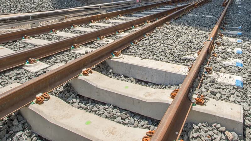 Newly laid Long Island Rail Road track on concrete ties and fresh ballast at a rail yard under construction.