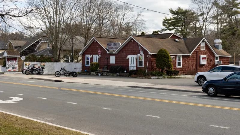 Two motorcycles parked beside a two-lane Main Street road on Long Island.