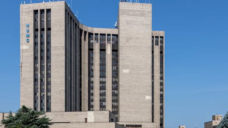 The tall concrete tower of Nassau University Medical Center in East Meadow against a blue sky.