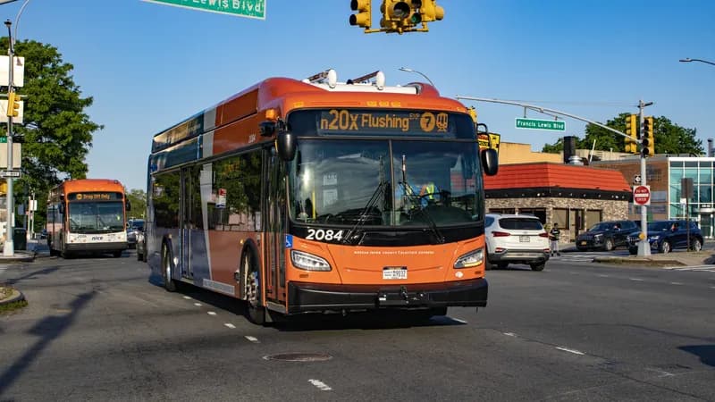 A Nassau Inter-County Express (NICE) bus on the n20X route at an intersection.