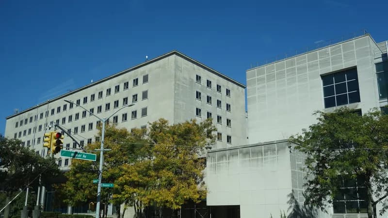 The Queens County Criminal Court buildings in Kew Gardens at Queens Boulevard and Hoover Avenue, with trees and street signs.