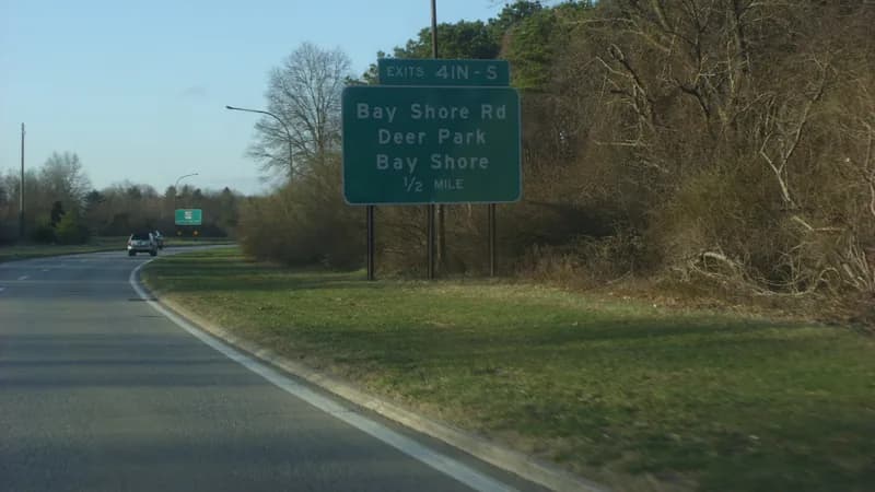 An exit sign for Bay Shore Road, Deer Park and Bay Shore beside the Sagtikos Parkway in Suffolk County.