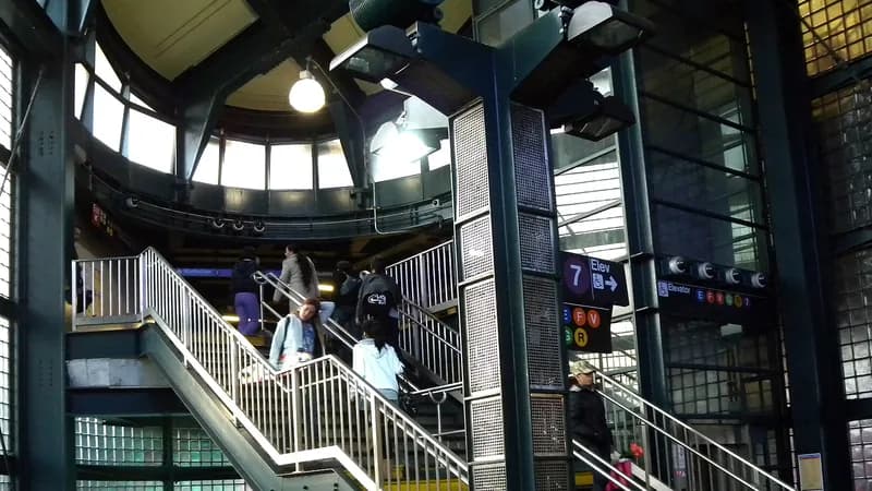 Riders on the interior stairs leading up to the elevated 74th Street platform at Roosevelt Avenue in Jackson Heights, Queens.
