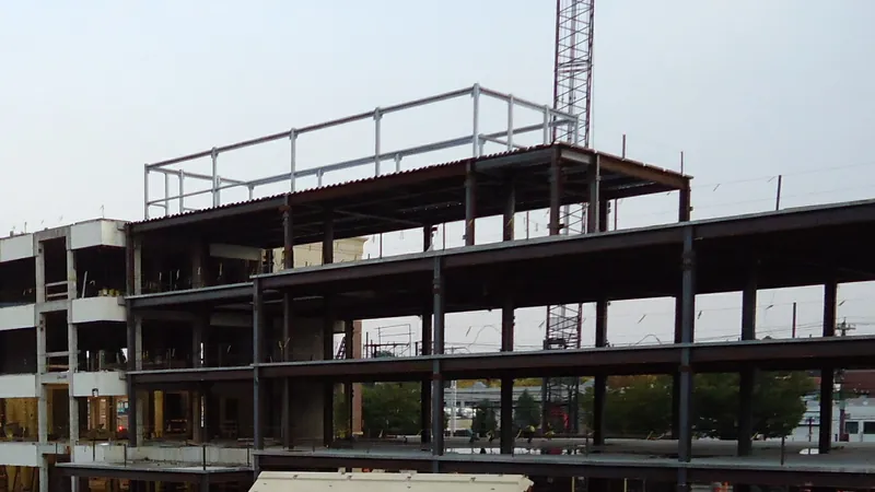 The steel frame of a multi-story building under construction beside a tower crane in Summit, New Jersey.