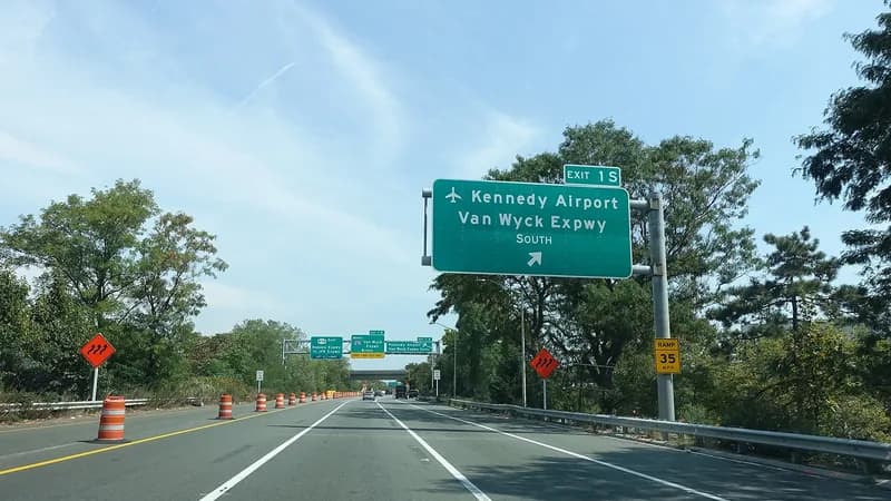 An overhead exit sign for Kennedy Airport and the Van Wyck Expressway South above the Nassau Expressway in Queens.